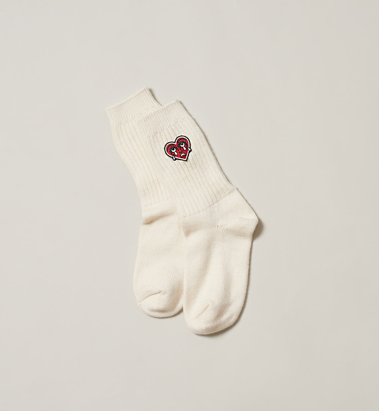 Natural sock with a red crying heart logo on a white background