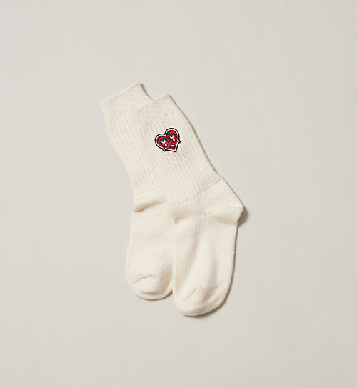 Natural sock with a red crying heart logo on a white background